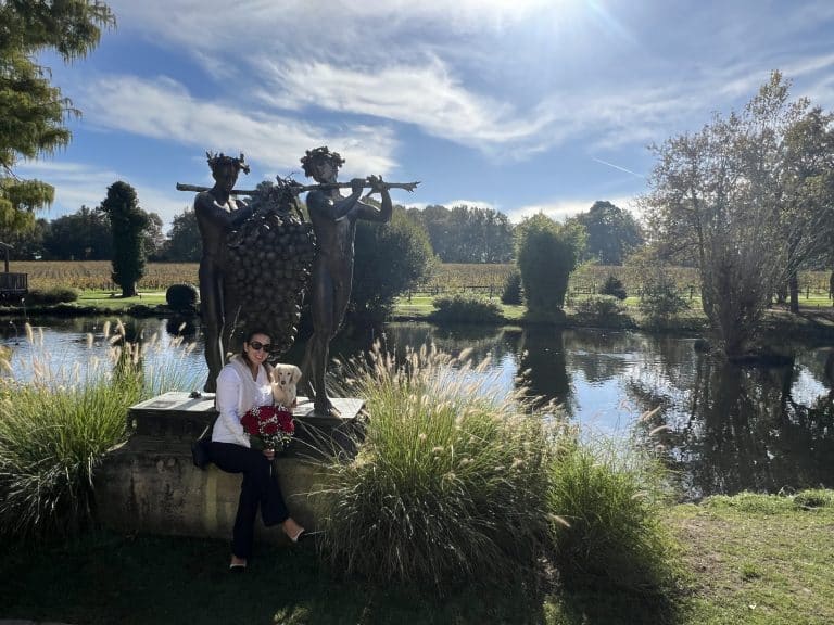 Les Sources de Caudalie, luxury vineyard retreat in Bordeaux femme de 40 ans avec dachshund au bord de l'eau devant oeuvre d'art.