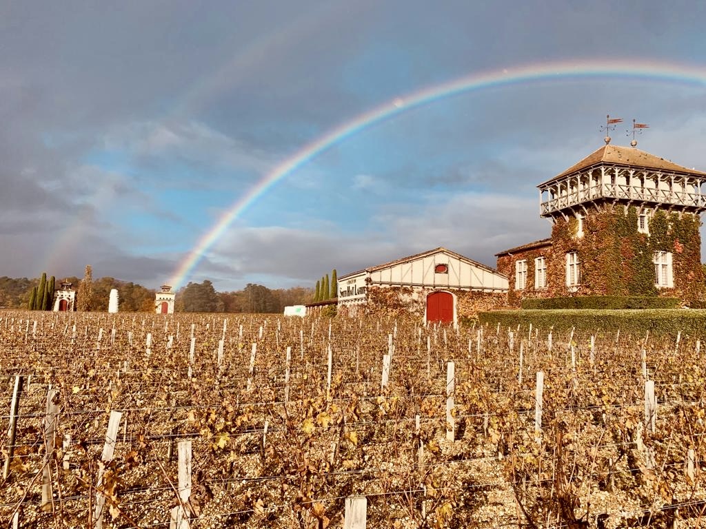 Autumn vineyards, wit Château Smith Haut Lafitte framed by a double rainbow at Les Sources de Caudalie.