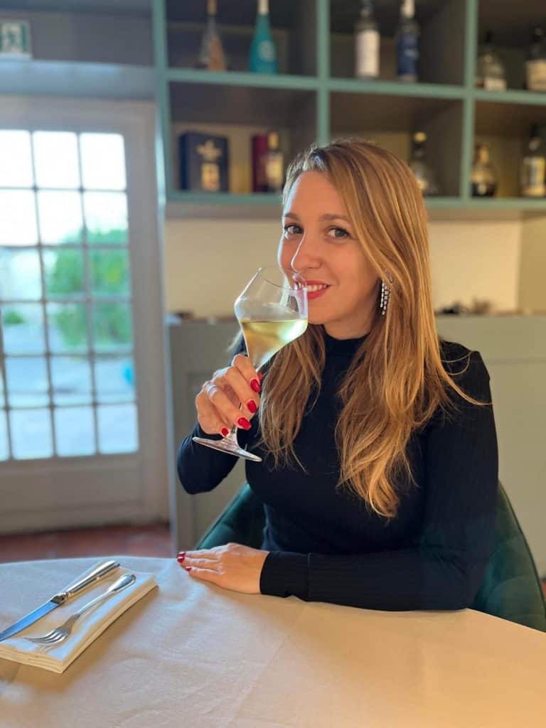 Elegant woman enjoying champagne at a luxury restaurant, representing reinvention at 40 with a travel lifestyle mindset on FirstClassBoardingPass