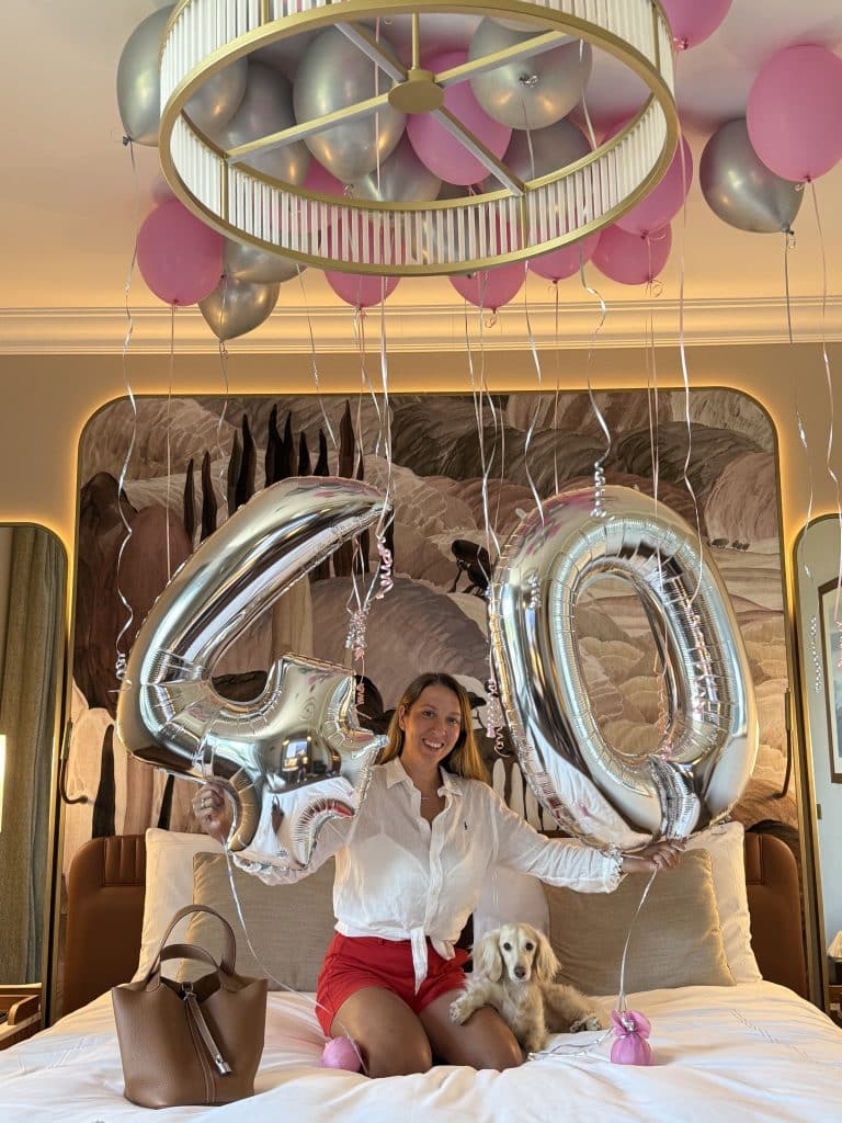 Luxury 40th birthday celebration in a hotel suite with balloons a dachshund and Hermes picotin bag, marking the beginning of reinvention and empowerment at 40.
