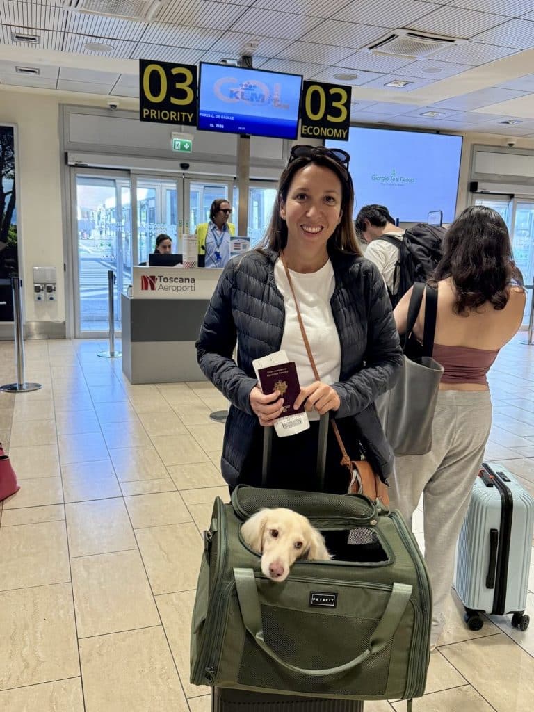 Midlife Reinvention, a 40-year-old woman with her cream dachshund Takkie in front of the airport departure gate, ready to embark on a new chapter.